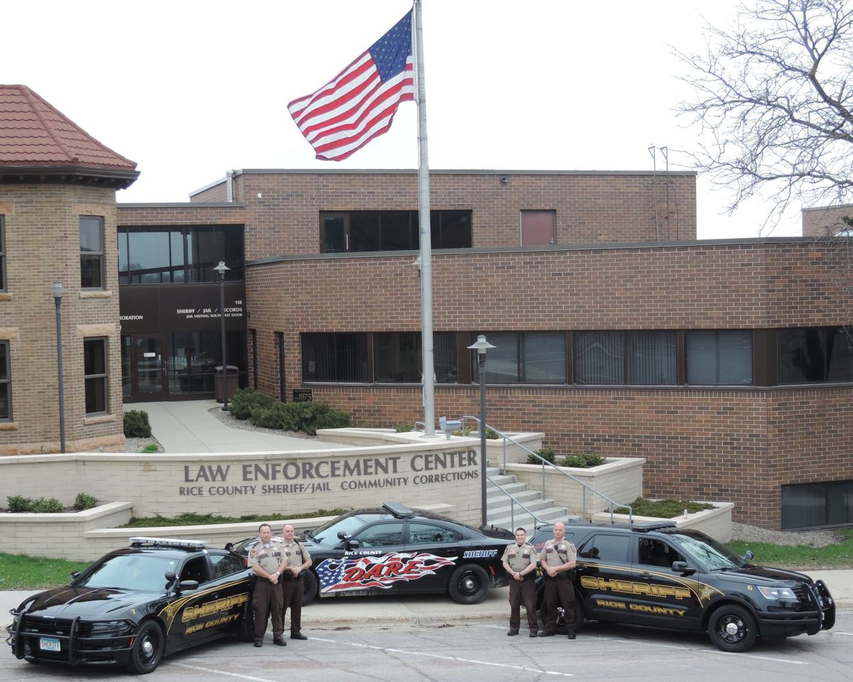 Sheriff officers posing in front of cars